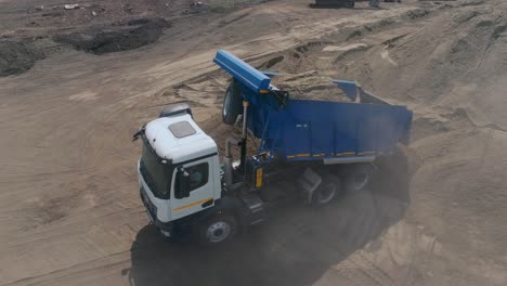 dump truck loading sand at construction site