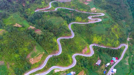 a winding wiggling road cut beautifully into the mountainside on the dong van karst plateau geopark