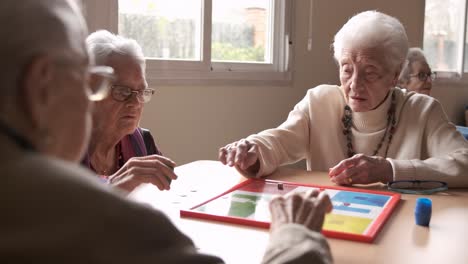 senior people playing board game in retirement home
