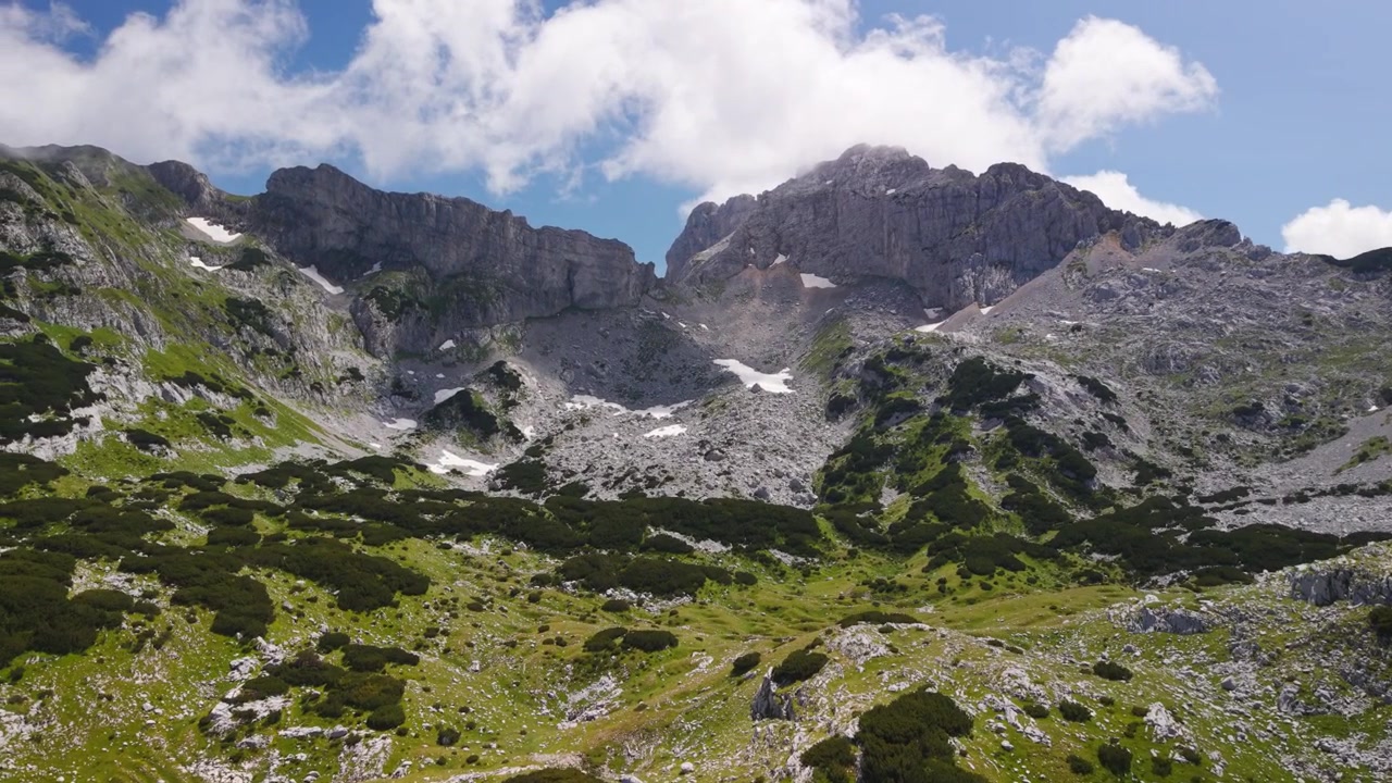 Vandrere hviler foran den majestætiske Bobotov Kuk-top i Durmitor Nationalpark, Montenegro