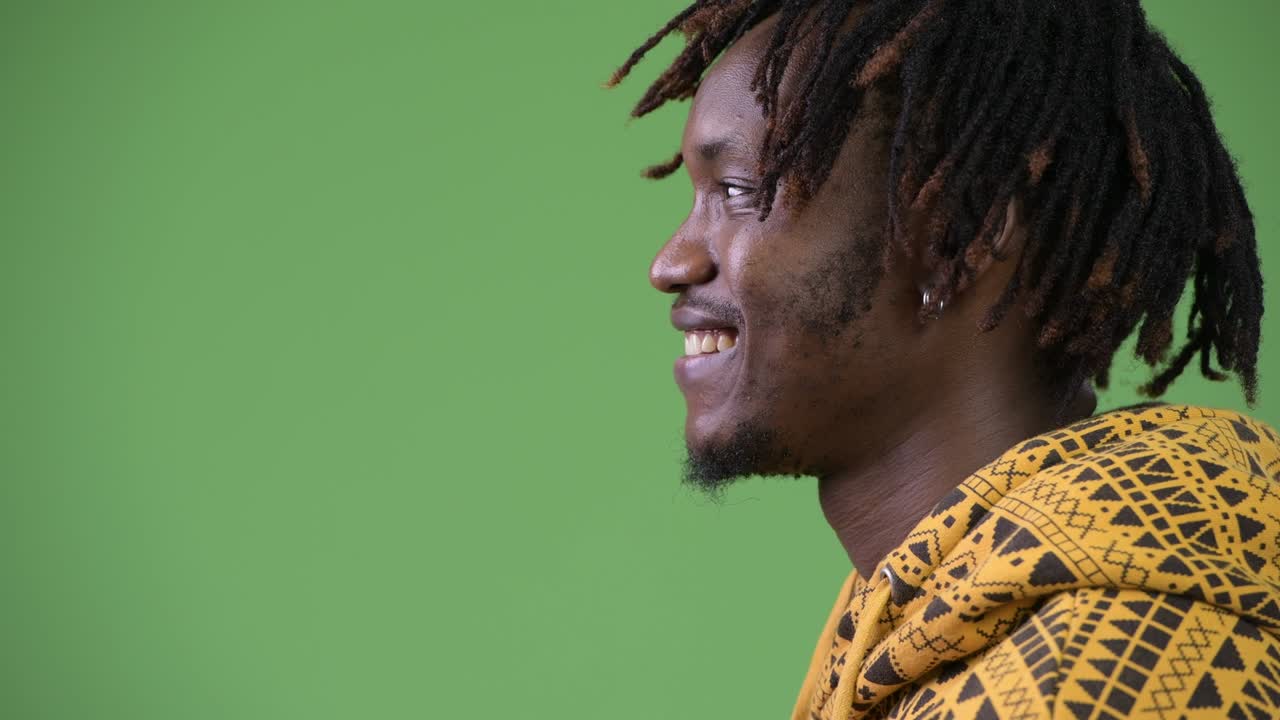 Profile view of young happy handsome African man smiling