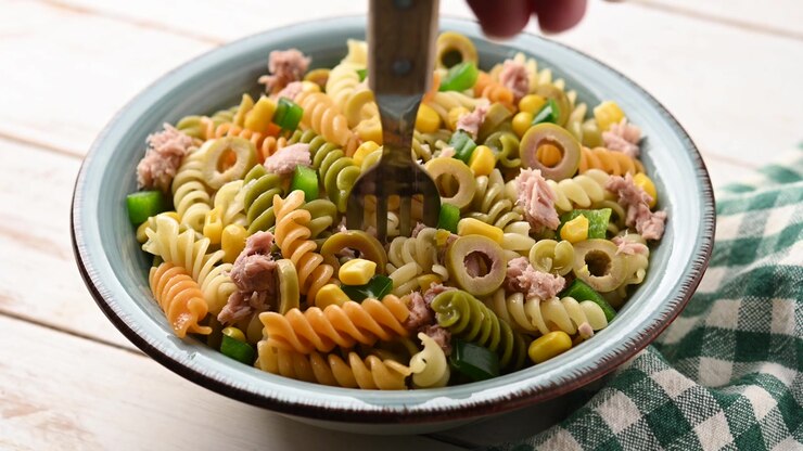 Insalata di pasta con tonno, mais e olive in una ciotola.