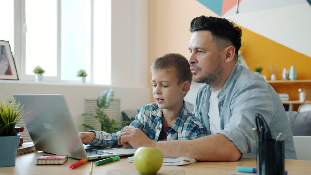 Father helping son with online learning