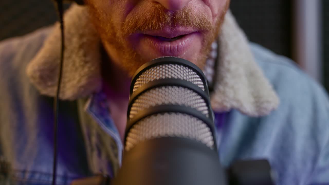 Close up on professional sound studio microphone in live radio show or podcast streaming. Recording session in audio booth. Man or host talks to mic during show. Cool hipster man speaks. Mouth moving