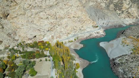 Toma-Aérea-De-Un-Río-Que-Fluye-A-Través-De-La-Ciudad-De-Skardu-En-Pakistán-Durante-La-Tarde.