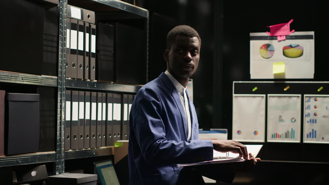 Man working in office with files and charts