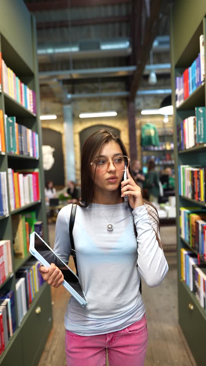 estudiante hablando por teléfono en la biblioteca