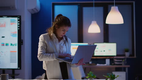 Focused-manager-woman-checking-business-reports-standing-in-start-up-office