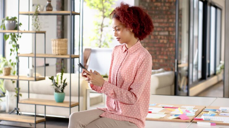 Using smartphone, woman smiling and working in creative writing business office