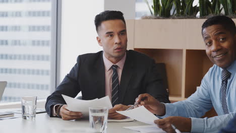 group of business professionals meeting around table in modern office