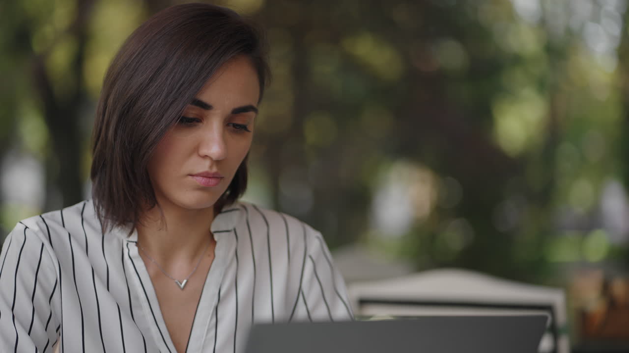 mujer serio talentosa morena árabe grupo étnico hispano se sienta en una mesa en un café de verano con una computadora portátil. considera resolver problemas. mujer de negocios desconcertada. retrato de una hermosa mujer de negocios