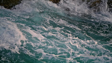 Olas-Espumosas-Chapoteando-En-La-Naturaleza-Del-Risco-De-Cerca.-Agua-Salada-Del-Mar-Chocando-Contra-Las-Rocas