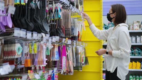 mujer comprando utensilios de cocina en una tienda de comestibles