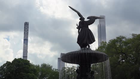 closeup view of a water fountain and sculpture against a background of new york city skyline-1