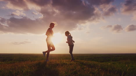 silhouette of a young woman with a child doing fitness in nature 1