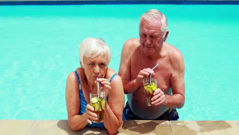 Pareja-De-Ancianos-Interactuando-Entre-Sí-Mientras-Toman-Vasos-De-Té-Helado