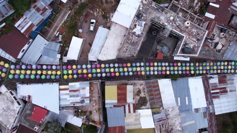 top down drone shot of colorful umbrella street, tourist attraction of san juan la laguna and lake atitlan, guatemala