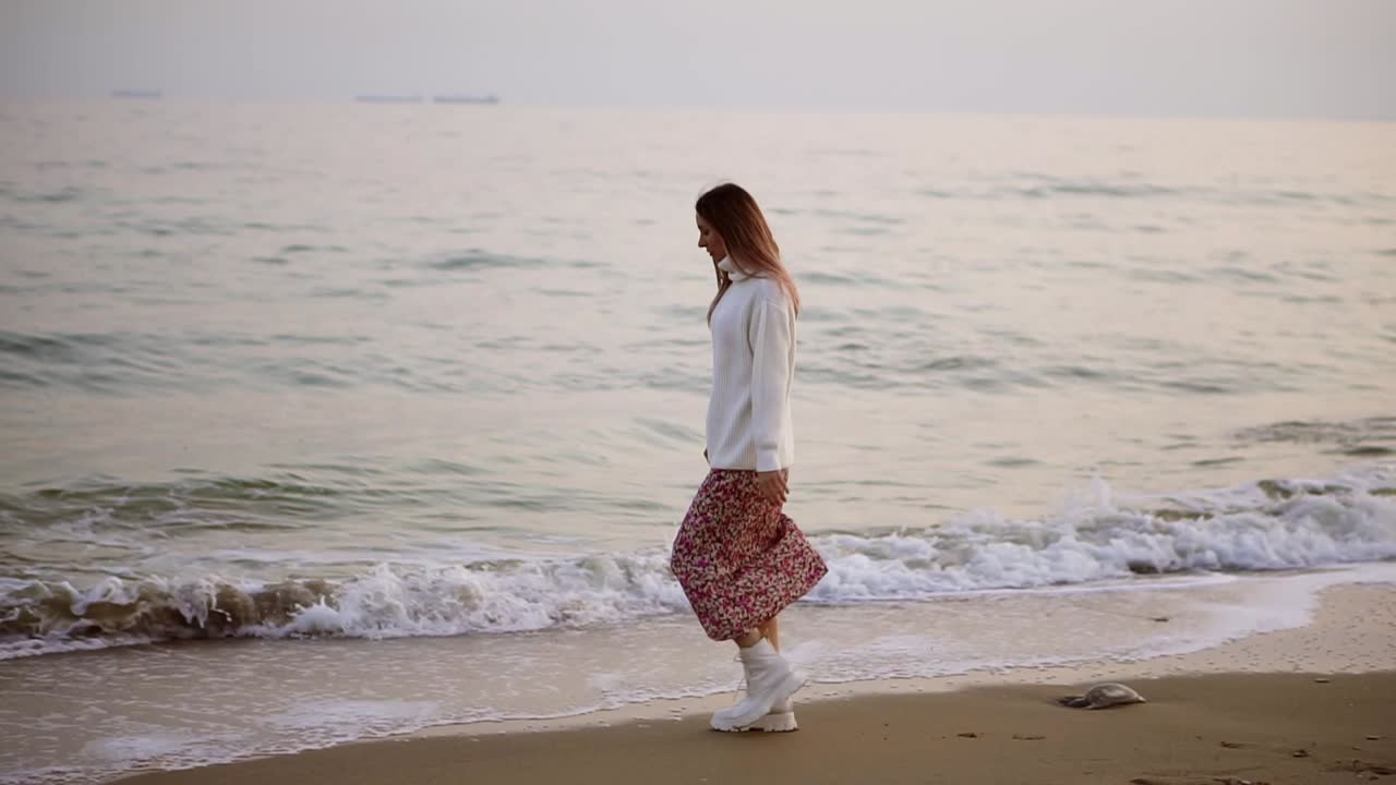 우아한 옷을 입은 소녀가  ⁇ 에서 바 ⁇ 가를 따라  ⁇ 고 있습니다.