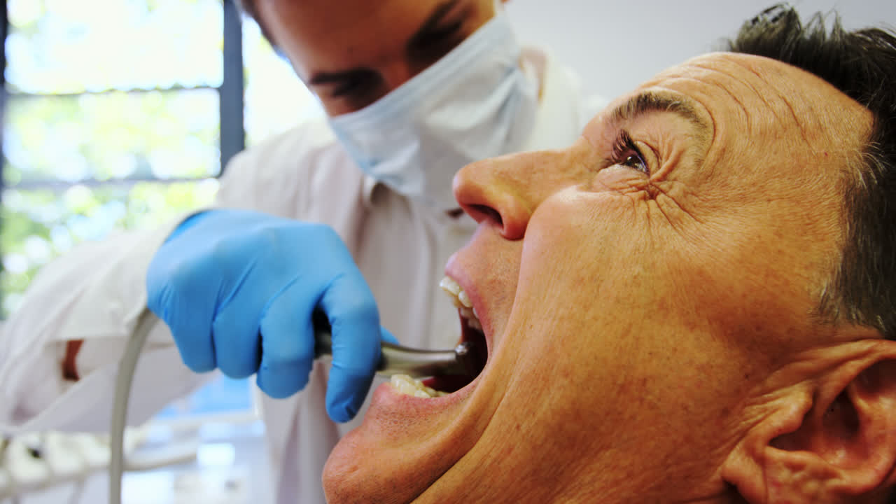 dentista examinando a un paciente masculino con herramientas