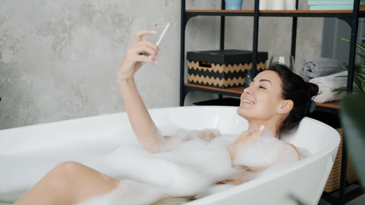 거품 욕조에서 셀피를 찍는 여자