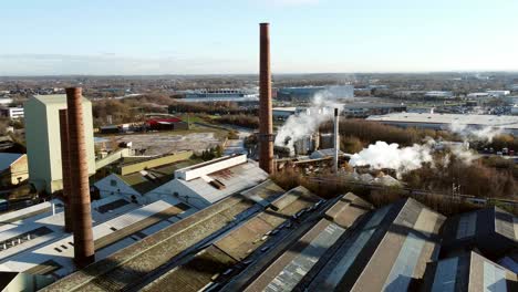 pilkington glass factory warehouse buildings aerial reversing orbit view across industrial town manufacturing facility