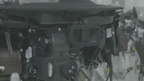 Factory Workers chassis on automated engine assembly line, focused technicians work meticulously on car components in an automotive parts factory