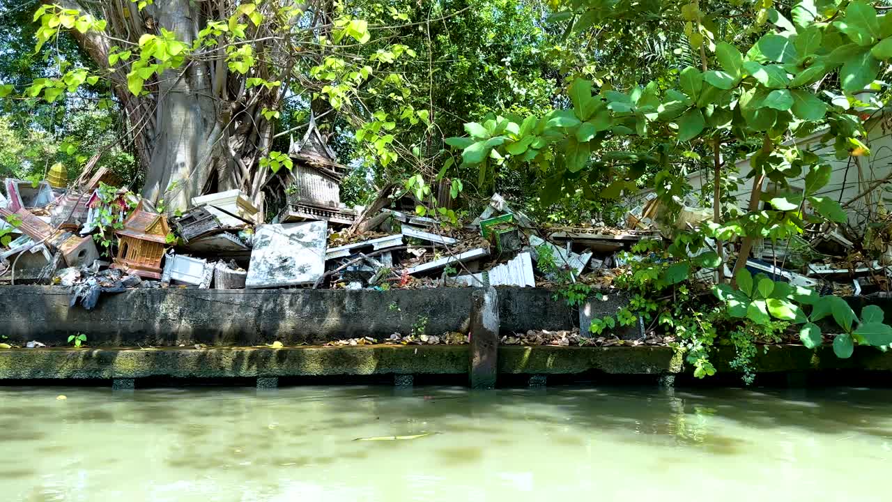 방의 떠다니는 시장에서 밝은 낮에 찍은 울창한 초록색과 시골적인 구조물과 함께 조용한 운하 전망