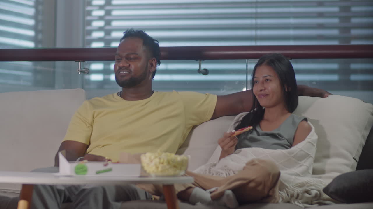 Couple Enjoying TV Show in Evening at Home