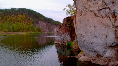 a trip along the river flowing among the dense forests. rocky mountain next to the reservoir, ripples on the surface of the water. active outdoor activities, soothing silence in the forest.