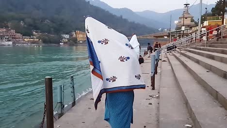 少女在日落时在河岸上享受,从平角度拍摄的视频是rishikesh uttrakhand india在2022年3月15日拍摄的