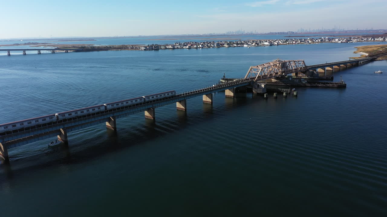 뉴욕 퀸즈의 만을 가로지르는 고가 선로에서 기차의 공중 촬영