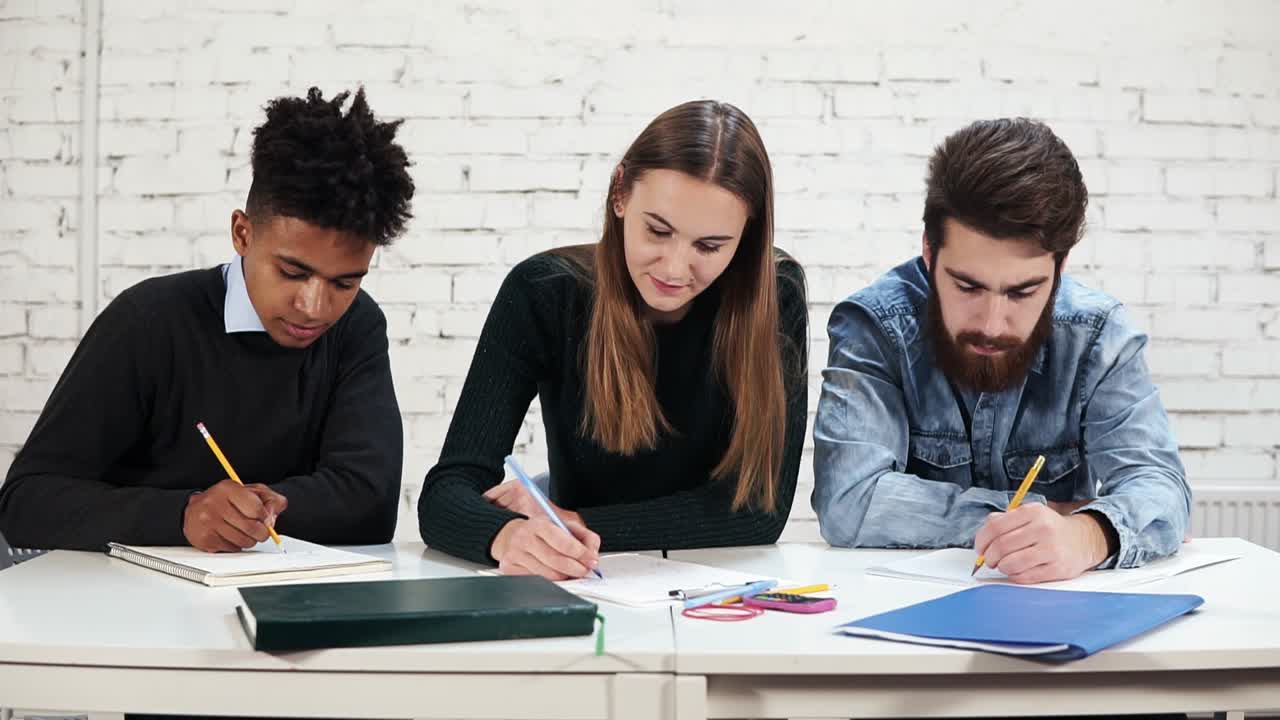 jóvenes estudiantes multiétnicos diversos escribiendo y examinando en la escuela o la universidad. prueba en la escuela. toma en cámara lenta