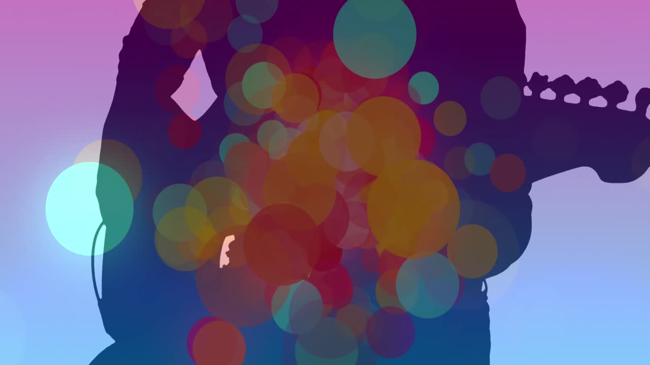 기타를 연주하는 사람의 실루 위에 움직이는 다채로운 반점의 애니메이션