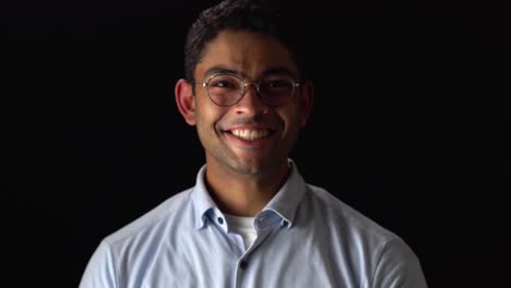 Funny-Young-Man-Moving-His-Ears,-Trying-Not-To-Laugh-Against-Black-Backdrop