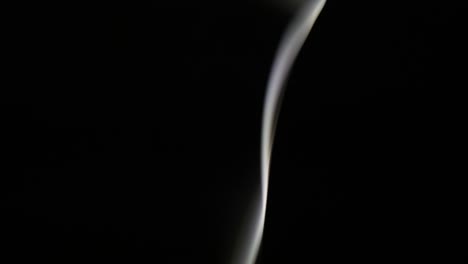el humo de un cigarrillo que se eleva sobre un negro