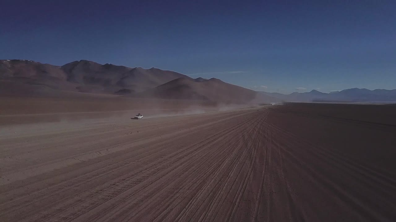 fotografía épica de drones de vehículos todoterreno que conducen por carreteras de tierra del desierto, la ruta de bolivia y chile