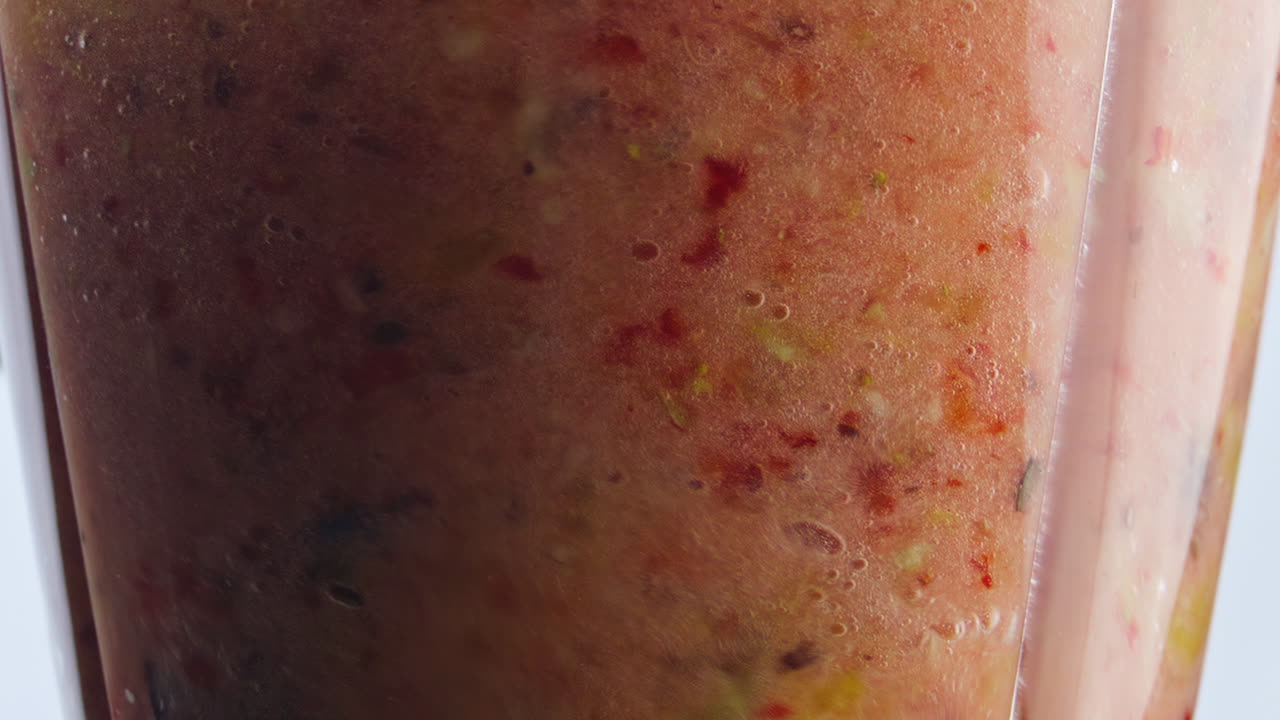 Shaking fresh fruit smoothie in blender close up. Blend with pieces ingredients.