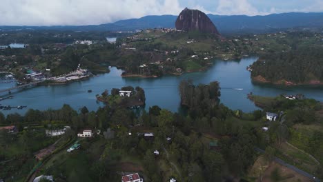 rivers of water by el penon de guatape rock in colombia, aerial at sunset