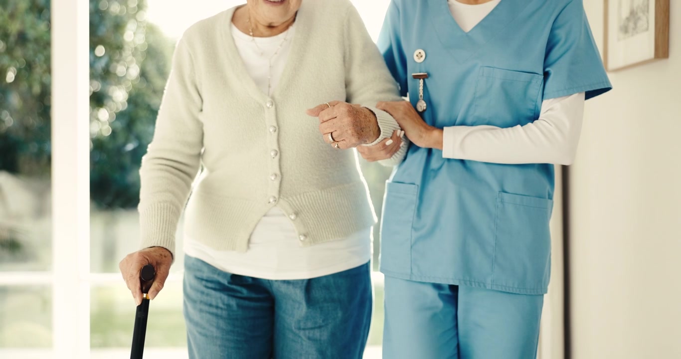 Caregiver Assisting Senior Woman Walking with Cane