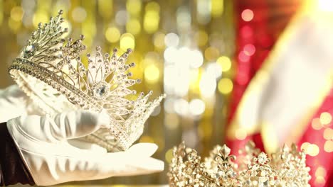 a pageant organizer checks the queen's diamond crown in preparation for the miss beauty contest - blurred bokeh background