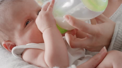 mother feeding baby drinking from milk bottle loving mom caring for infant at home motherhood responsibility 4k