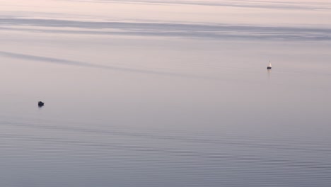 夕暮れ時の湖に浮かぶ2隻の孤独なボートの抽象的なショット