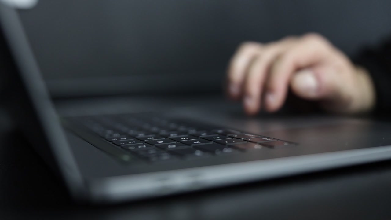 노트북 마우스를 조작하는 손의 영화 같은 상세 클로즈업. 디지털 탐색, 생산성, 기술, 현대 컴퓨터 사용을 나타내는 스크롤 및 클릭 동작이 특징