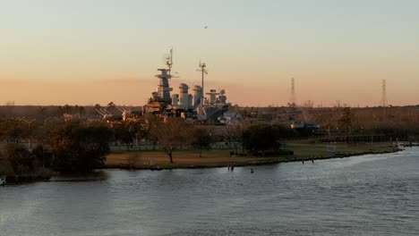 USS-North-Carolina-battleship-at-golden-hour-establishing-aerial