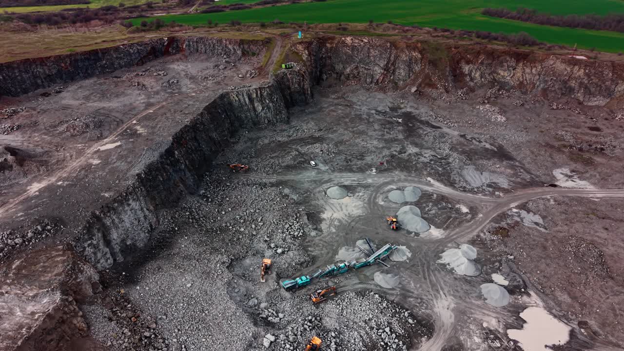 Heavy machines work in granite quarry located in rural area