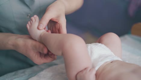 niño pequeño en pañal blanco se encuentra en la mesa de cambio