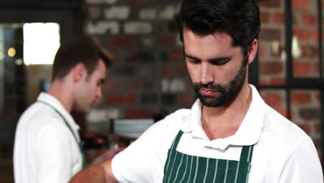 Lächelnder-Kellner,-Der-Sandwiches-Mit-Einer-Zange-Auswählt