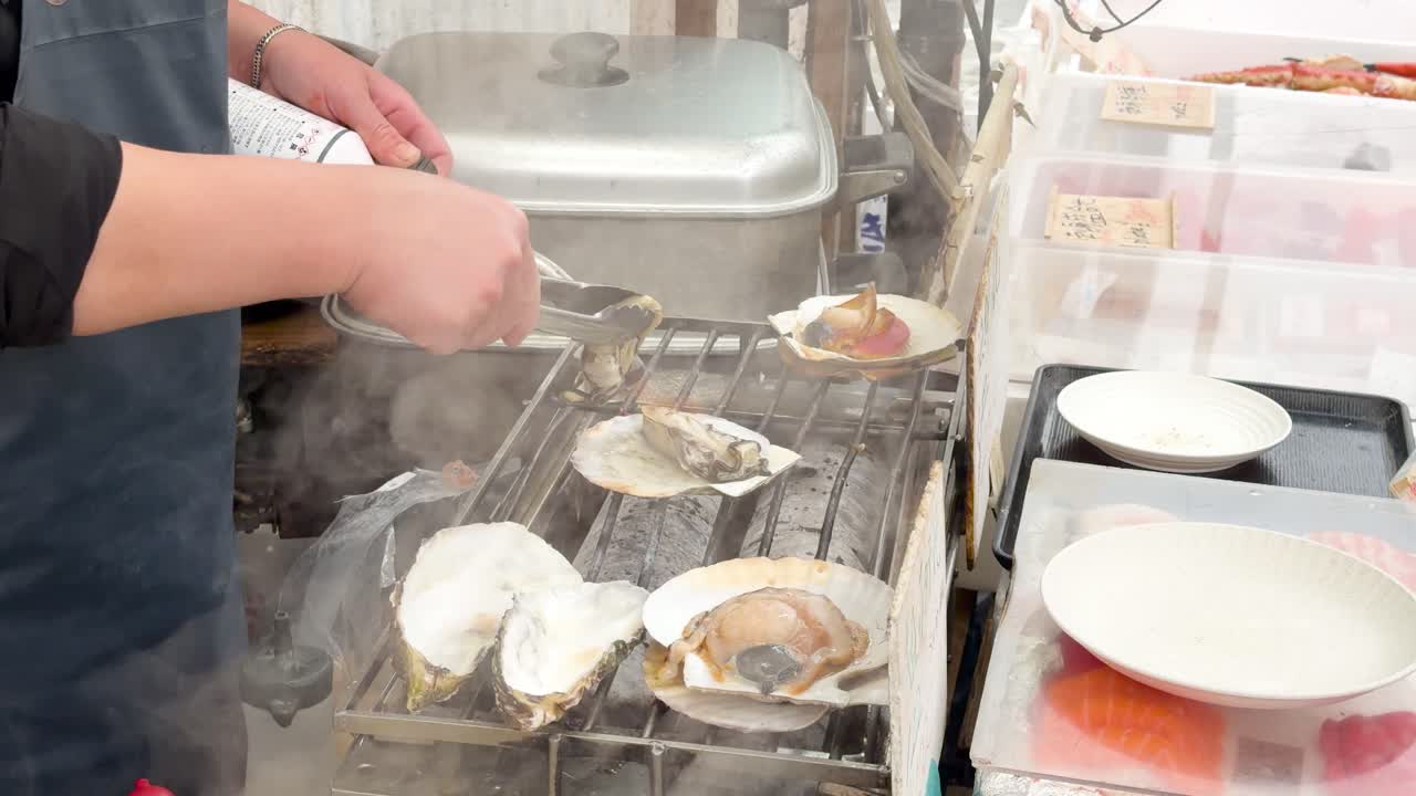 Close-up of a chef using a blowtorch and tongs to grill fresh seafood in Tokyo