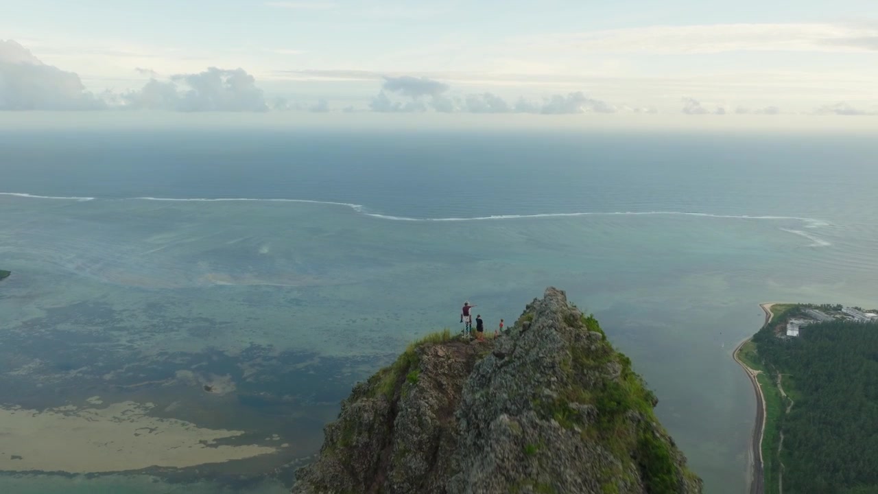 Ripresa con drone di Le Morne Brabant che mostra persone in piedi accanto alla croce in cima all'escursione