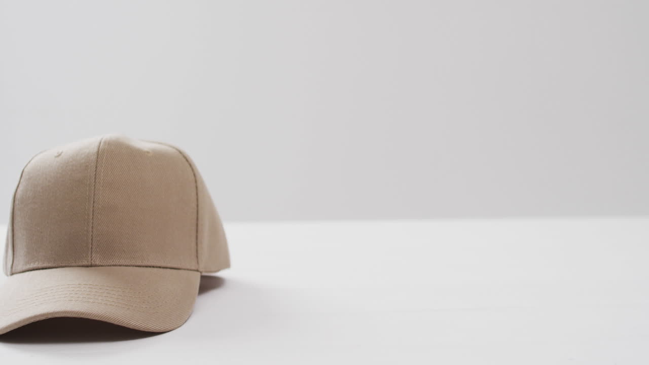 ⁇ 색 배경에 베이지 야구 모자와 복사 공간의 비디오